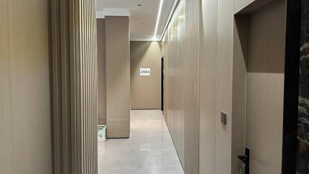 A corridor with a modern design, featuring a light-colored floor and walls with vertical lines. - Hongdu Hotel (Tongxiang)