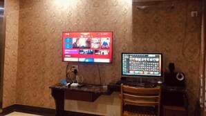 A room with a wall-mounted TV, a desktop computer, a desk, and a chair. - Hongdu Hotel (Tongxiang)
