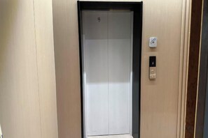 An elevator with a control panel and a door. - Hongdu Hotel (Tongxiang)