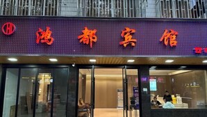 A hotel entrance with a digital sign displaying the name in red characters. - Hongdu Hotel (Tongxiang)