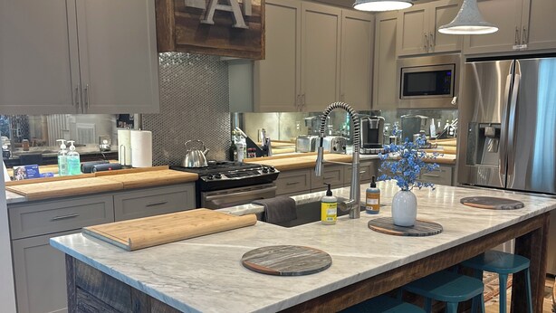 A modern kitchen with a large island, bar stools, and stainless steel appliances. - Great Location!  Charming 3-bedroom townhome in brilliant Nashville w/ AC, WiFi (Nashville)