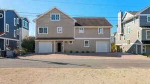 A two-story residential house with a front garage, a driveway, and a gravel front yard.