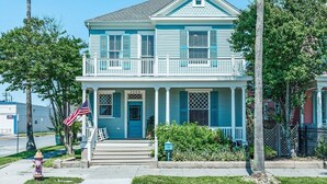 A two-story house with a porch, a front door, and a mailbox. - La Onda Azul (Galveston)