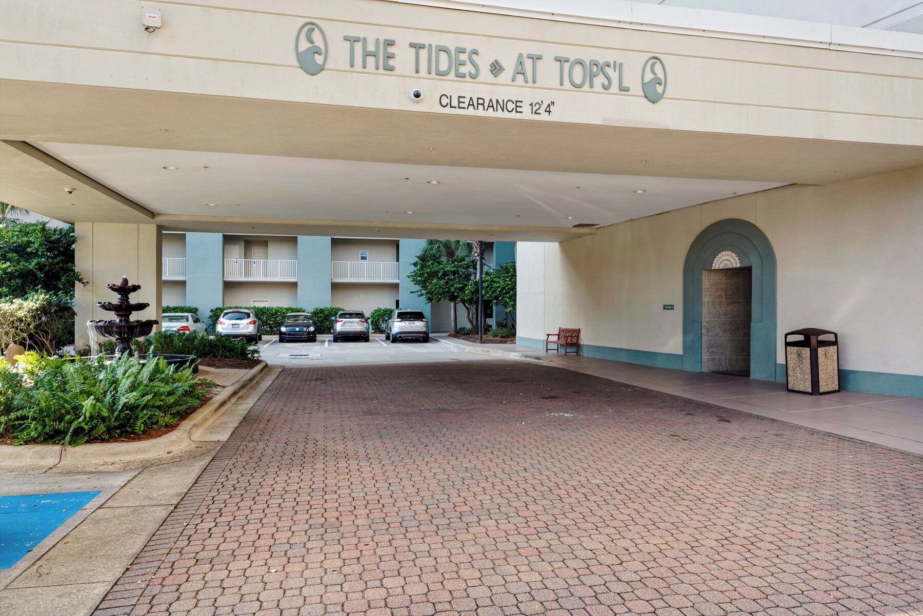Een hotelingang met een bord waarop "The Tides at Tops" staat en een vrije hoogte van 3,8 meter.