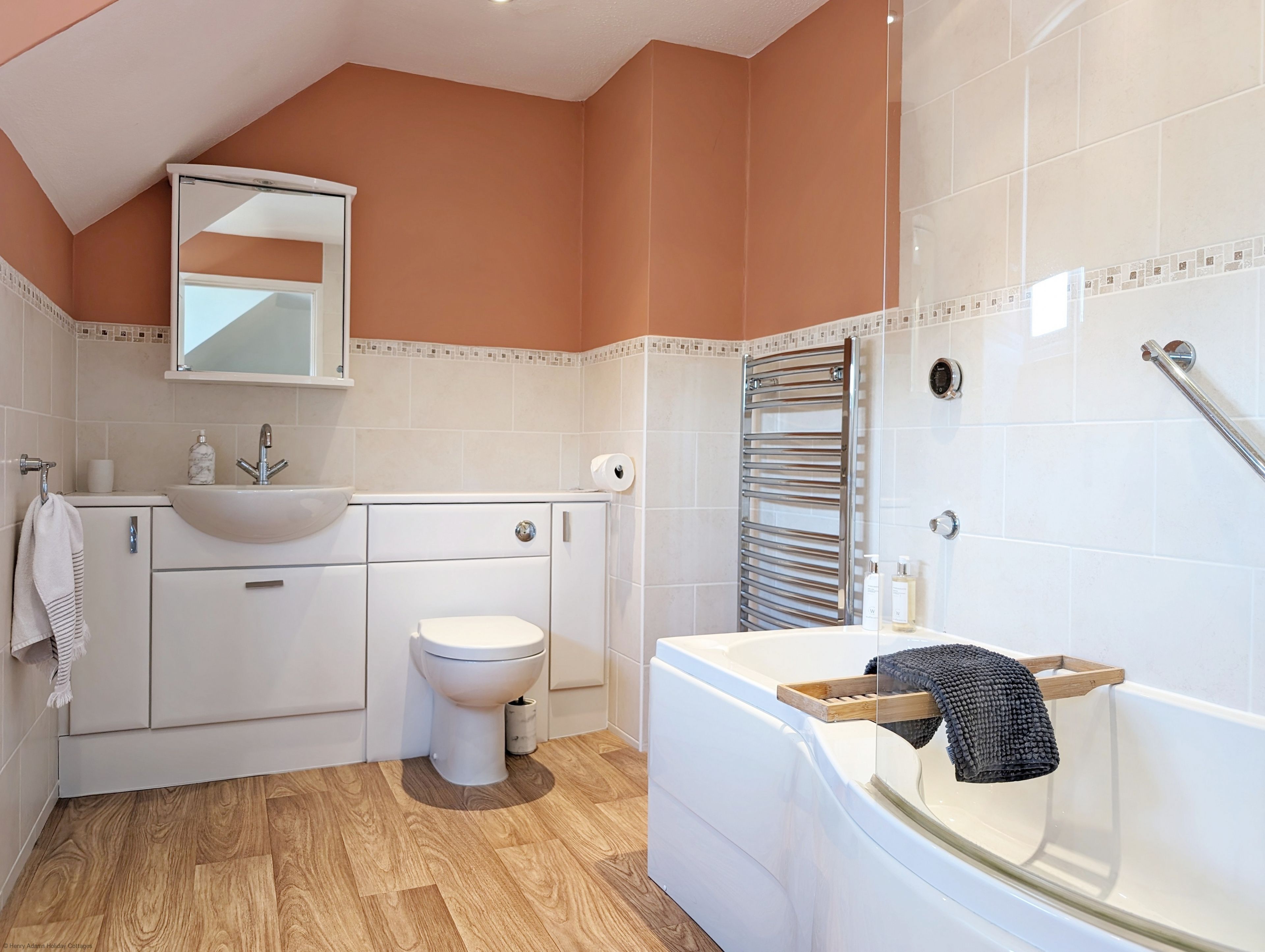 A modern bathroom with a white sink, toilet, and bathtub.
