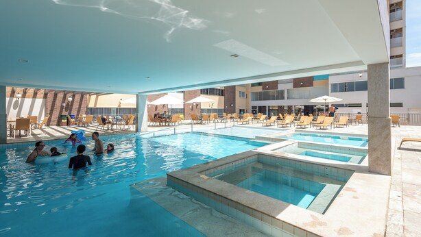 A swimming pool area with multiple pools and lounge chairs. - DiRoma Piazza - Direto com o Grupo DiRoma - acesso ao Acqua Park com café da manhã (Caldas Novas)