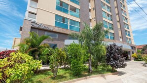 A multi-story hotel with a modern design, featuring a prominent entrance and a well-maintained garden with various plants. - DiRoma Piazza - Direto com o Grupo DiRoma - acesso ao Acqua Park com café da manhã (Caldas Novas)