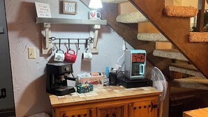 A kitchen with a coffee station, a coffee maker, a fan, and a trash bin. - Cozy 3 bedroom with loft,  condo in welcoming Angel Fire with WiFi (Angel Fire)
