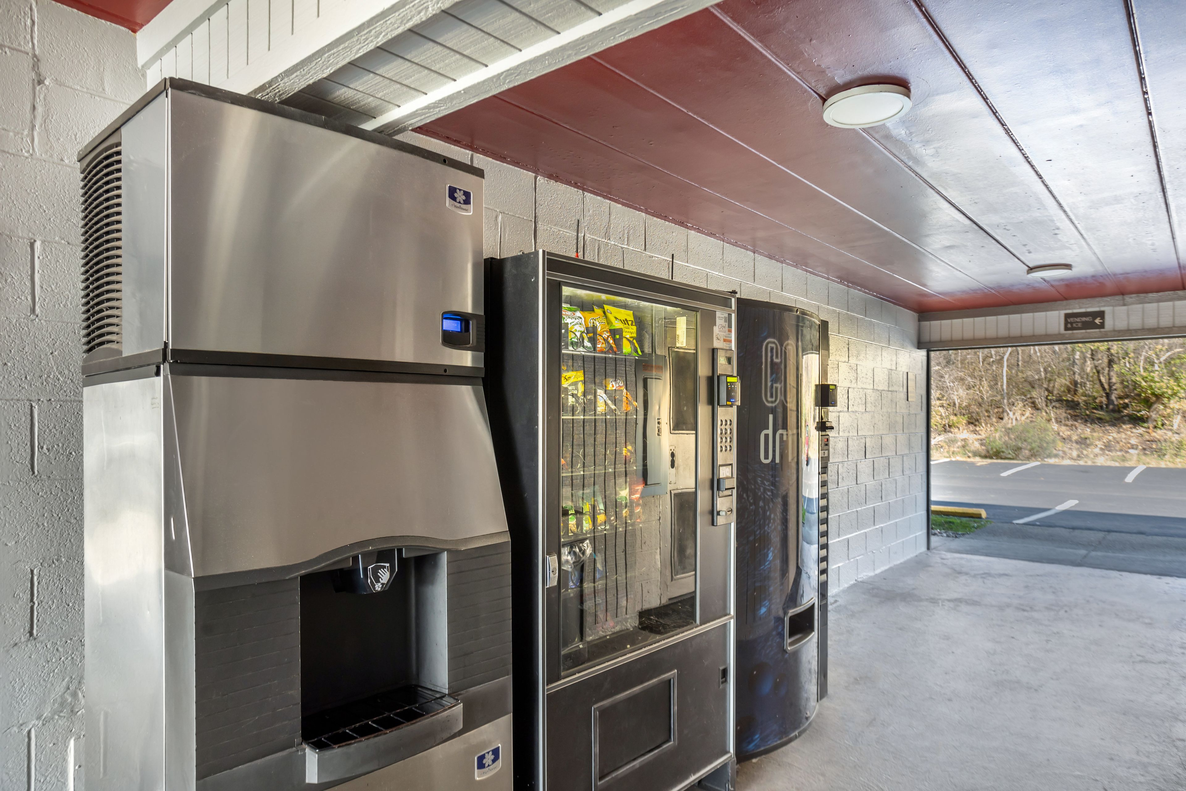 Un dispensador automático de bebidas con pantalla digital, un refrigerador de bebidas y una máquina expendedora de aperitivos.