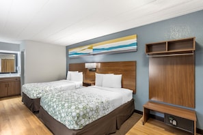 A hotel room with two beds, a wooden headboard, a bedside table, a wardrobe, and a painting on the wall. - HomeTowne Studios by Red Roof Danville, PA (Danville)