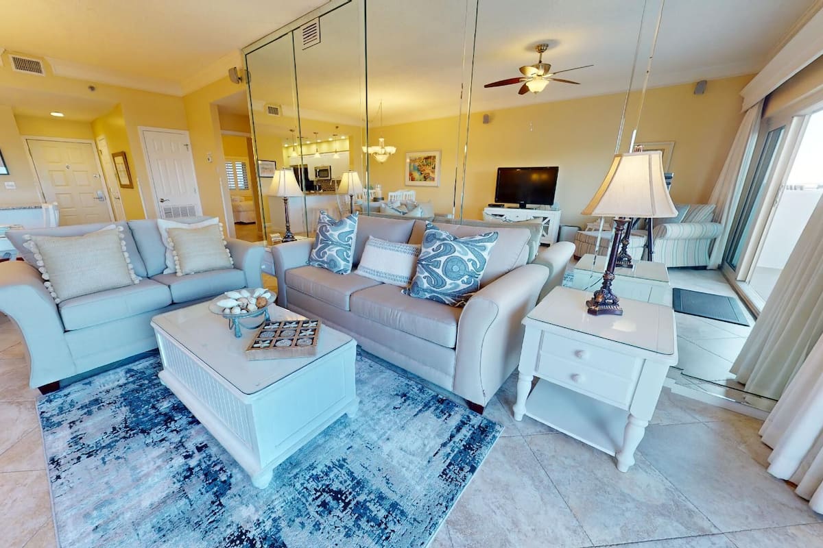 A spacious living room with a sofa set, a coffee table, and a TV.