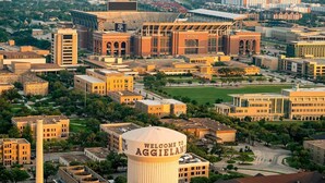 A university campus with a prominent water tower displaying "WELCOME TO AGGIELAND".