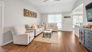 Una sala de estar con sofá, mesa de centro y ventilador de techo.