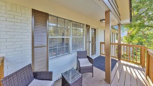 A covered porch with wicker furniture and a view of greenery. - Charming 3-bedroom bungalow with WiFi in Bham, 12 mins from UAB. (Birmingham)