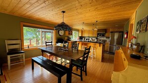 A spacious kitchen with wooden cabinets, a large island, and a dining area with a bench.