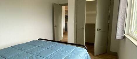 Un dormitorio con cama, ventilador de techo y ventana.