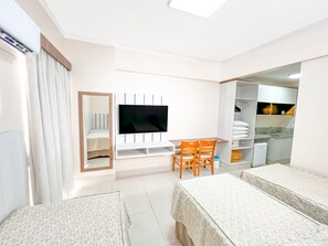 A compact room with a TV, a small table with chairs, a wardrobe, and a bed. - DiRoma Spazzio - Direto com o Grupo DiRoma - acesso ao Acqua Park com café da manhã (Caldas Novas)