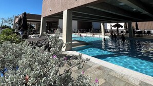 Ein modernes Gebäude mit Poolbereich, Liegebereich und überdachter Terrasse.