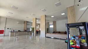 Eine geräumige Lobby mit einer Rezeption, großen Säulen und einer Ausstellung aus kuscheligen Spielzeugen.