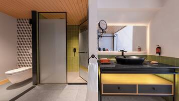 A modern bathroom with a toilet, a shower, and a sink with a mirror.
