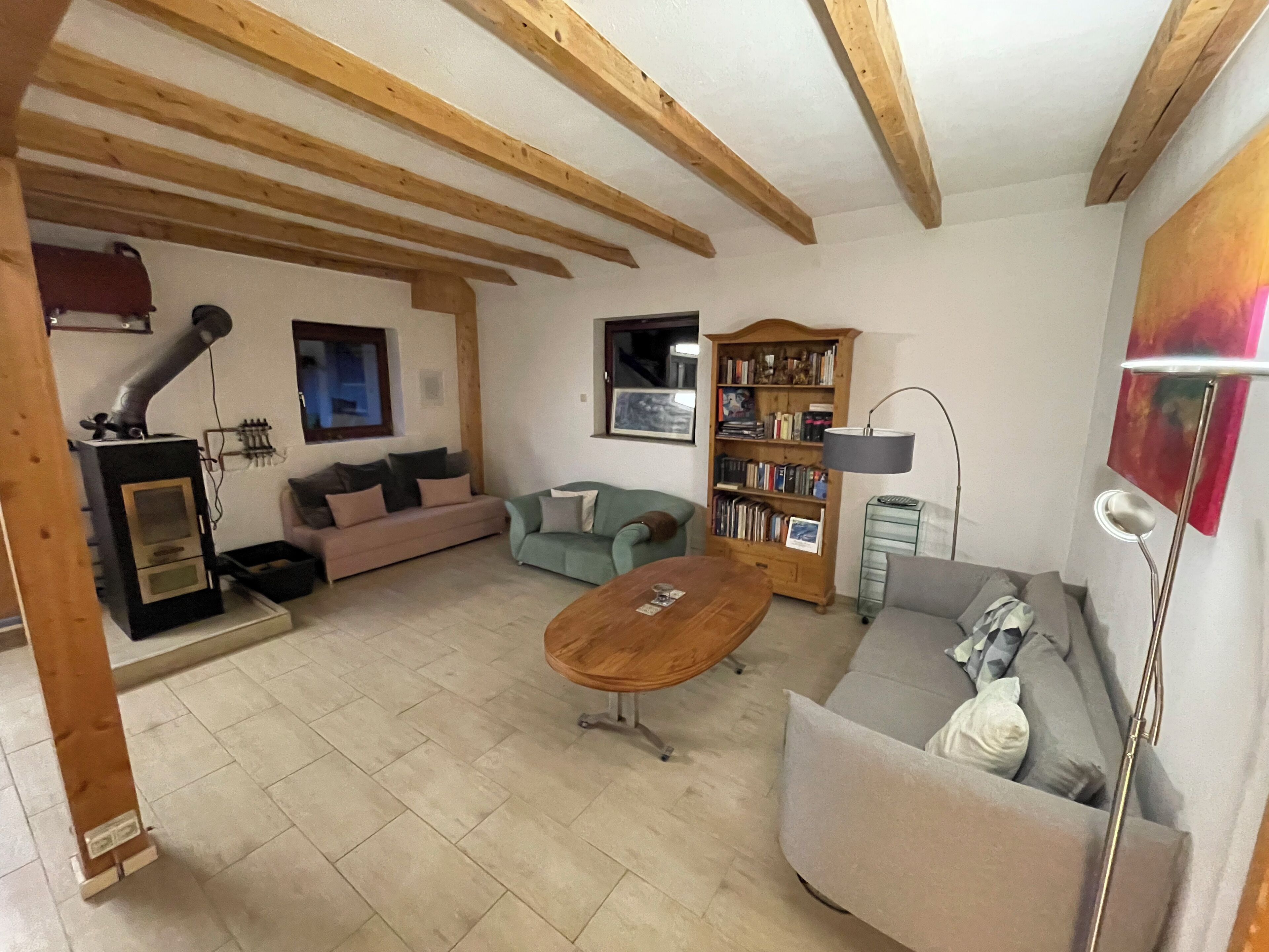 Una sala de estar acogedora con chimenea, sofás, una mesa de centro y una estantería.