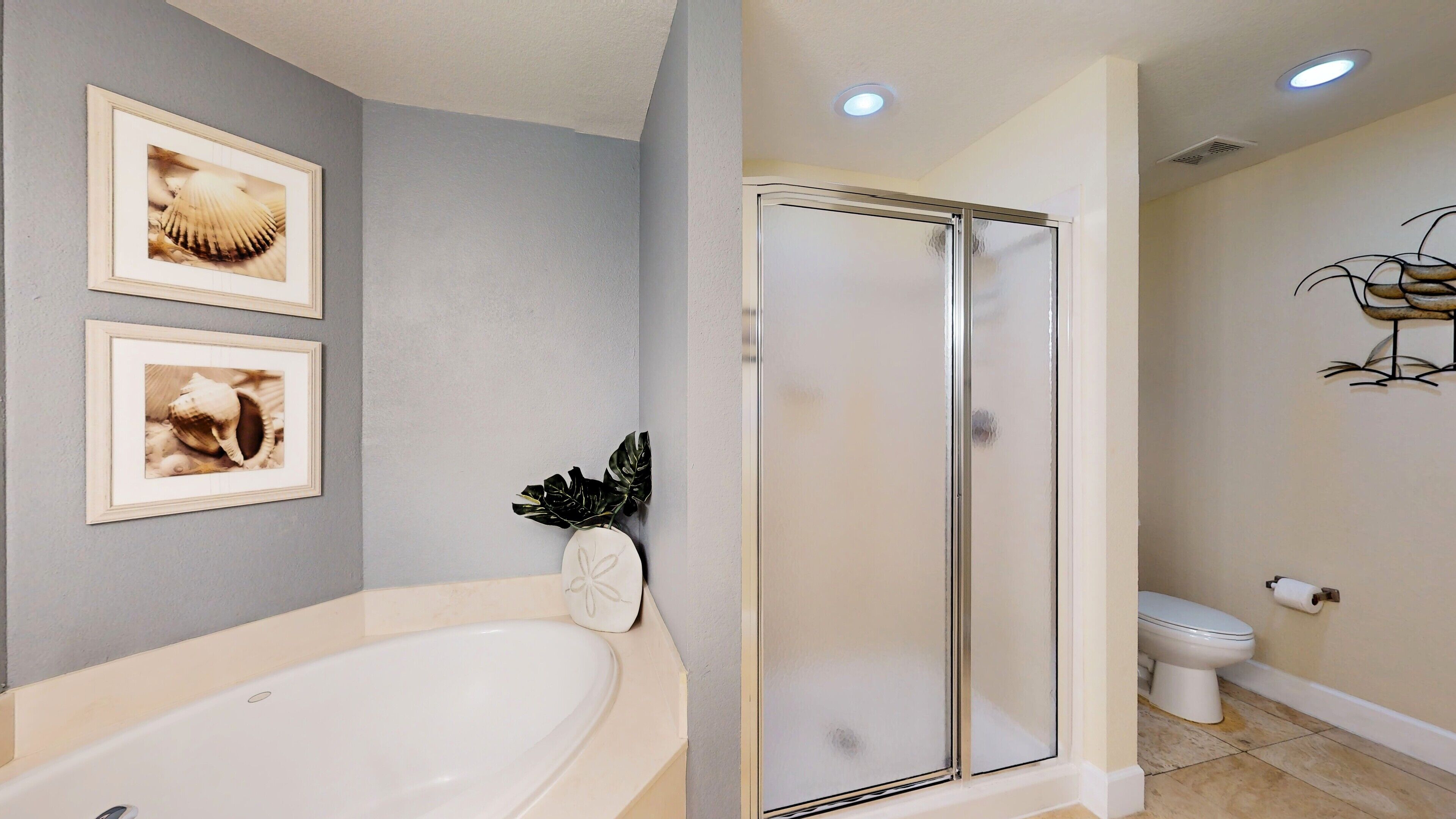 A bathroom with a bathtub, a glass shower enclosure, and a toilet.