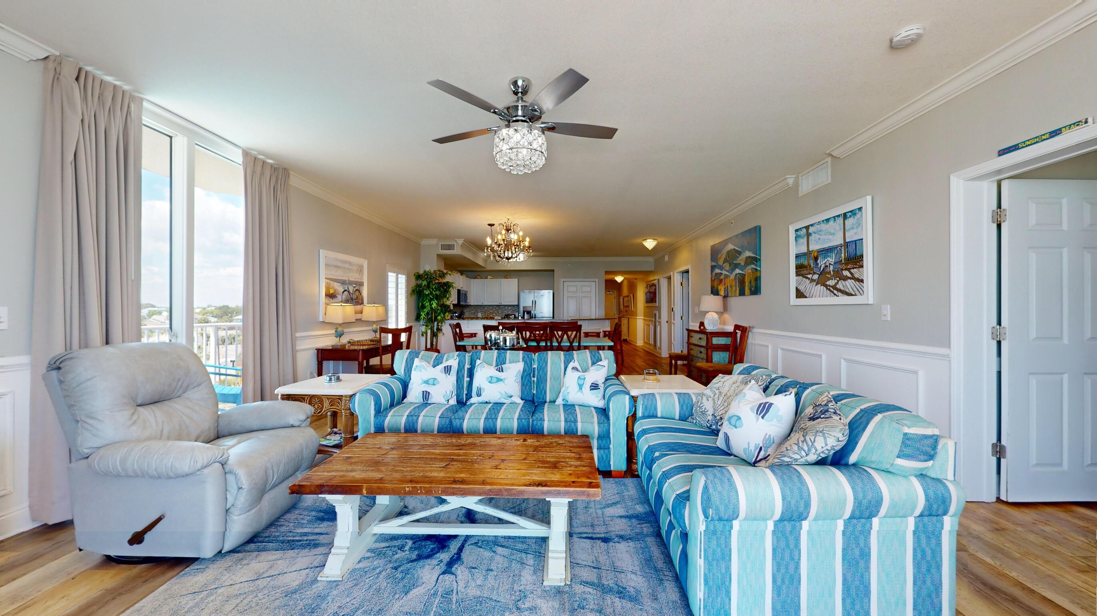 A spacious living room with a large sofa, a wooden coffee table, and a dining area in the background.