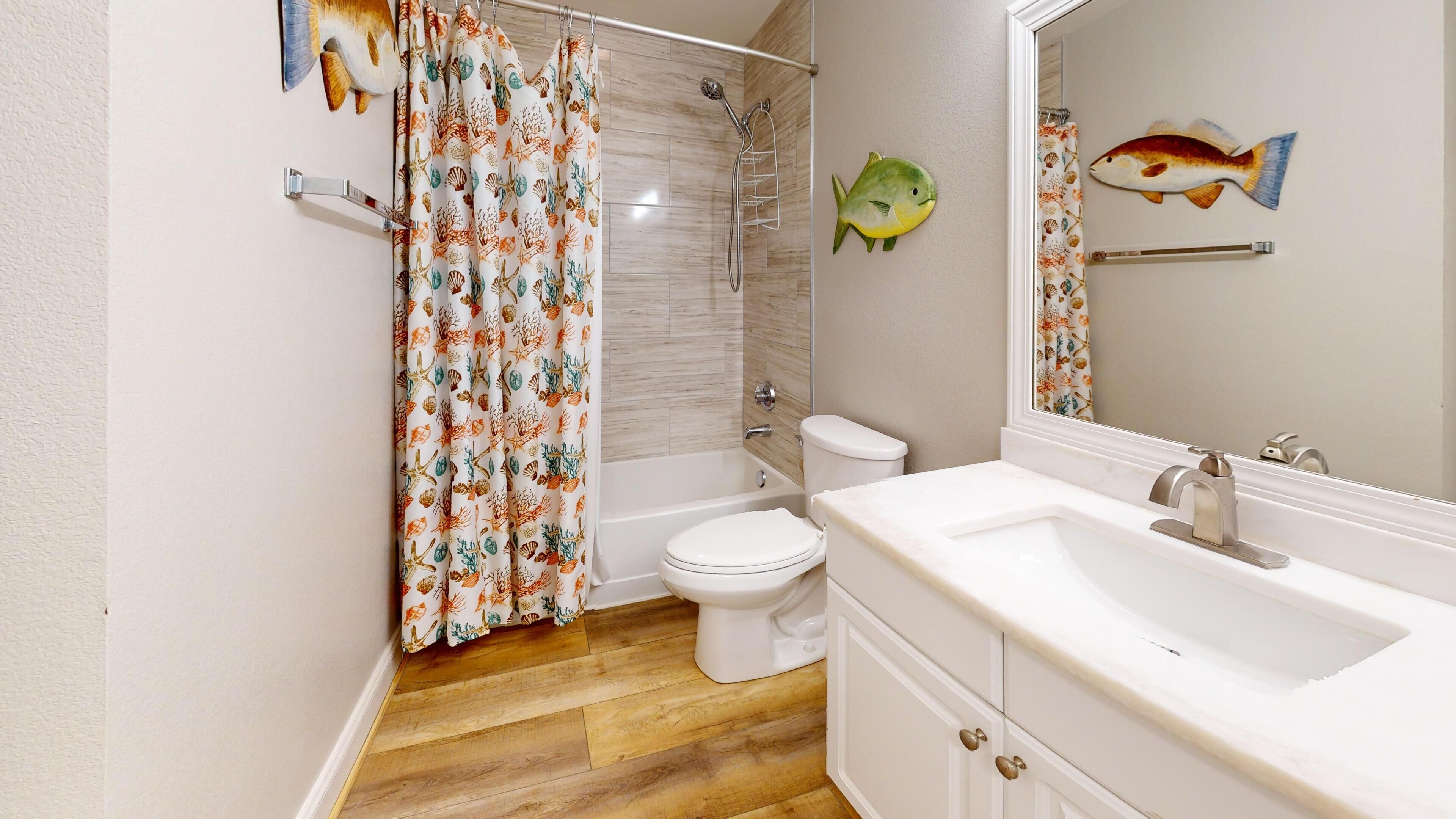 A bathroom with a shower, toilet, and sink.
