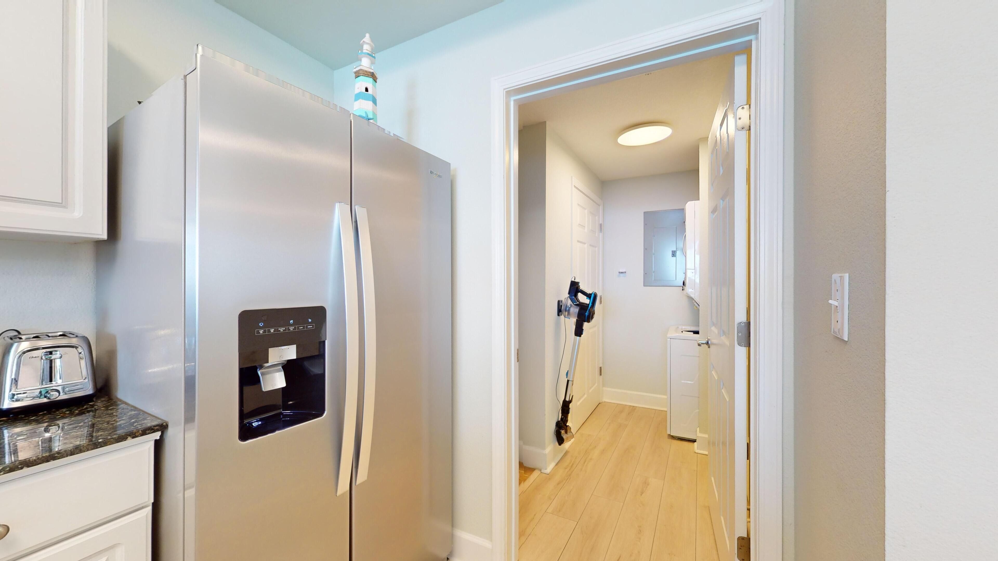 A modern kitchen with a built-in refrigerator, a water dispenser, and a toaster.