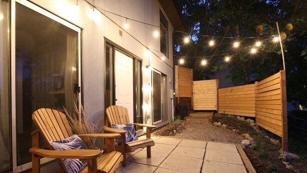 Eine Terrasse im Freien mit Holzstühlen und Lichterketten.
