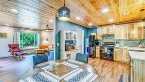 A modern kitchen with wooden cabinets, a built-in oven, and a large window. - Renovated Franklin Home w/ Mountain-View Deck! (Franklin)