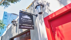Un letrero que dice 'PUCCLANA Lodge Bed & Breakfast' y 'DECORARQHOME' en la fachada de un edificio.
