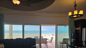 A living room with a large sliding glass door leading to a beach view. - Oceanfront 3 bdrm home.  Miramar Escape.  AC, Wi fi, Icemaker.   Beach! (Puerto Penasco)