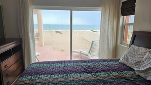 A bedroom with a bed, a dresser, and a view of the beach. - Oceanfront 3 bdrm home.  Miramar Escape.  AC, Wi fi, Icemaker.   Beach! (Puerto Penasco)