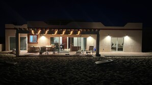 A modern house with a covered patio area, a dining table, and chairs. - Oceanfront 3 bdrm home.  Miramar Escape.  AC, Wi fi, Icemaker.   Beach! (Puerto Penasco)