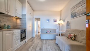 A modern kitchen with white cabinets, a built-in oven, and a wooden backsplash. - Holiday Home 'Sky View' with Sea View, Shared Pool and Air Conditioning (Paduledda)