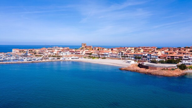 A coastal town with a marina, buildings with red-tiled roofs, and a prominent tower. - Holiday Home 'Sky View' with Sea View, Shared Pool and Air Conditioning (Paduledda)