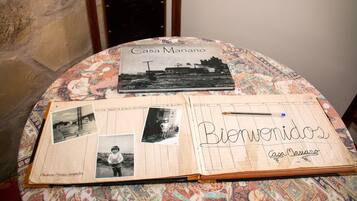A notebook with 'Bienvenidos' and 'Casa Mariano' written on it, placed on a patterned tablecloth.