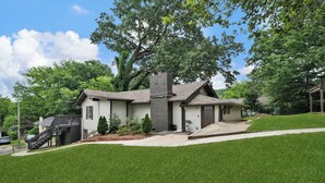 A two-story house with a chimney, a front porch, and a staircase leading to the entrance. - 3-bedroom vacation home 12 mins from University of Alabama-Birmingham &Hospital (Birmingham)