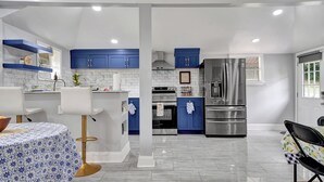 A modern kitchen with blue cabinets, white countertops, and stainless steel appliances. - 3-bedroom vacation home 12 mins from University of Alabama-Birmingham &Hospital (Birmingham)