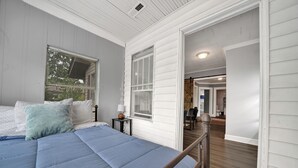 A bedroom with a bed, a nightstand, a window with blinds, and a door leading to another room. - 3-bedroom vacation home 12 mins from University of Alabama-Birmingham &Hospital (Birmingham)