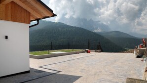 A building with a wooden roof and a view of green mountains.