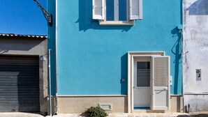 A building with a blue facade, a white door, and a window with shutters. - Holiday Home 'Il Rifugio Di Franz' with Air Conditioning (Vernole)