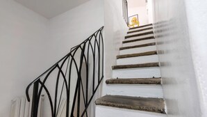 A staircase with a black metal railing and white walls. - Heart of Florence: Central, Cozy Apt with Elevator (Firenze)