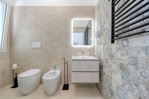 Une salle de bain moderne équipée de toilettes, d’un bidet et d’un meuble-lavabo.