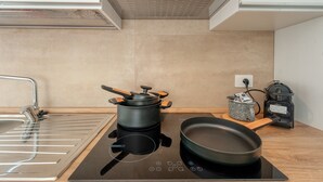 A modern kitchen with a built-in stove, a sink, and a kettle.