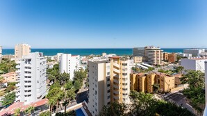 A coastal cityscape with high-rise buildings, a clear blue sky, and a view of the sea. - MalagaSuite Seaview Babilonia (Torremolinos)