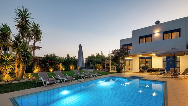 A swimming pool with lounge chairs and a modern building with a blue door. - Villa Mariani II (Rhodes)