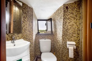 Un baño con lavamanos, inodoro y ventana.