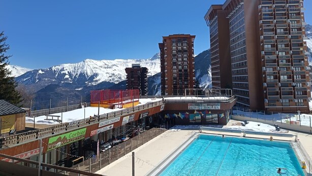 Een hotel met een zwembad, skiverhuur en uitzicht op de bergen.